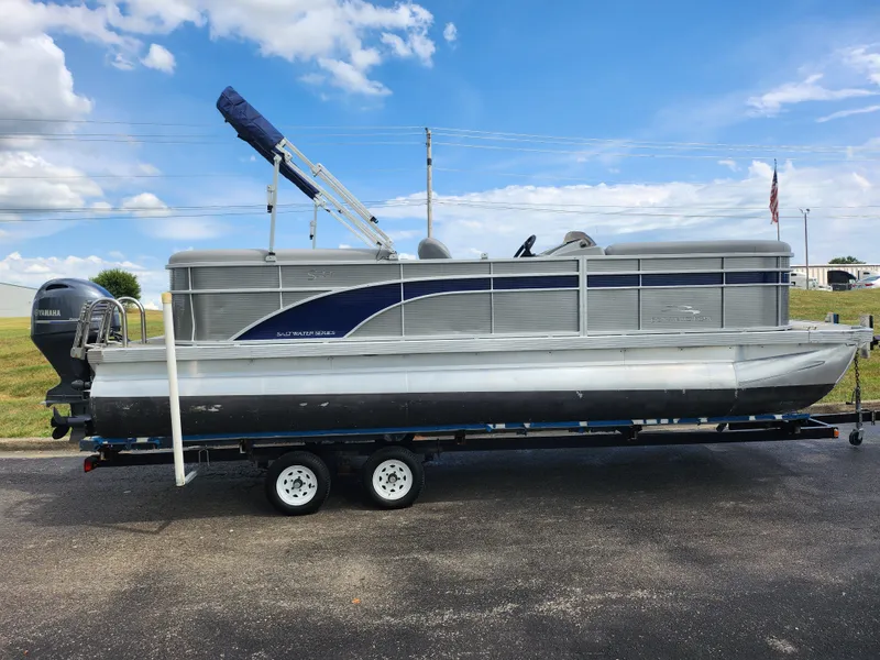 Slide: The Image of 2022 Bennington S 22 SSR pontoon boat on trailer under blue sky. - 5