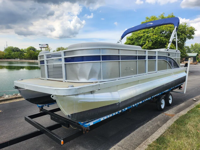 Slide: The Image of 2022 Bennington S 22 SSR pontoon boat on trailer by a lake. - 9