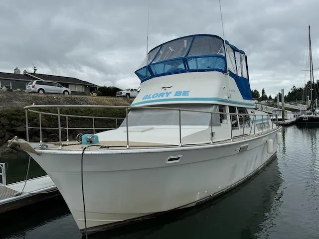 The Image of 1974 Tollycraft 40 Tri-Cabin boat docked in a marina under cloudy skies. - 0