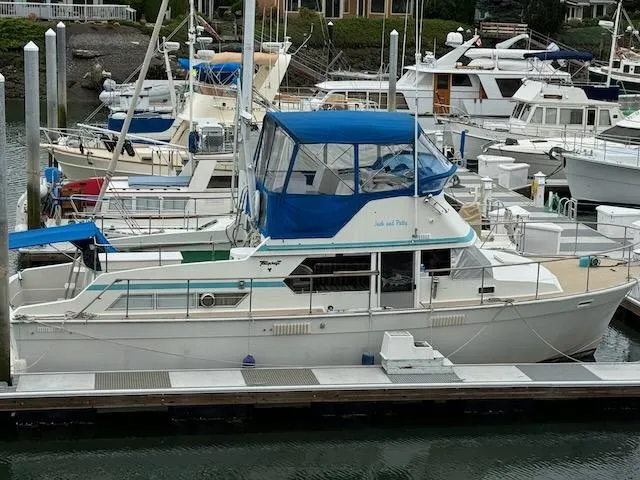 Slide: The Image of 1974 Tollycraft 40 Tri-Cabin yacht docked in a marina with blue canopy. - 1