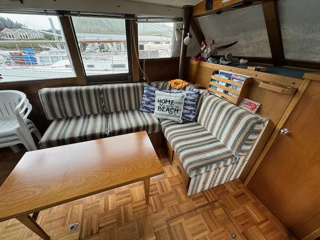 Slide: The Image of 1974 Tollycraft 40 Tri-Cabin interior with striped seating, wooden table, and nautical decor. - 10