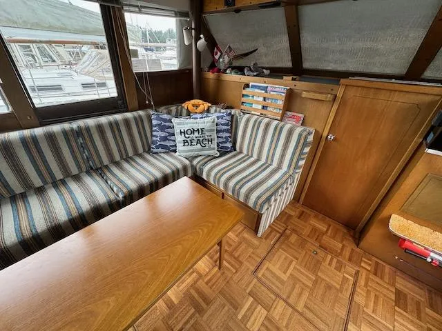 Slide: The Image of 1974 Tollycraft 40 Tri-Cabin interior with striped seating, wooden table, and nautical decor. - 11