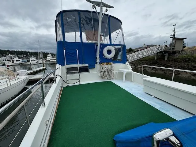 Slide: The Image of 1974 Tollycraft 40 Tri-Cabin yacht with green deck, docked at marina. - 13