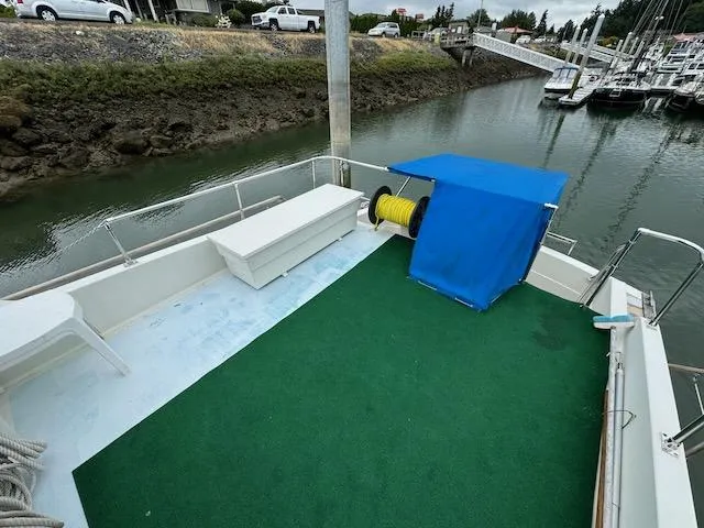 Slide: The Image of 1974 Tollycraft 40 Tri-Cabin boat deck with green carpet and blue canopy at marina. - 14