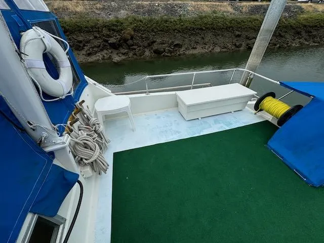 Slide: The Image of 1974 Tollycraft 40 Tri-Cabin deck with green carpet, ropes, and life preserver. - 16