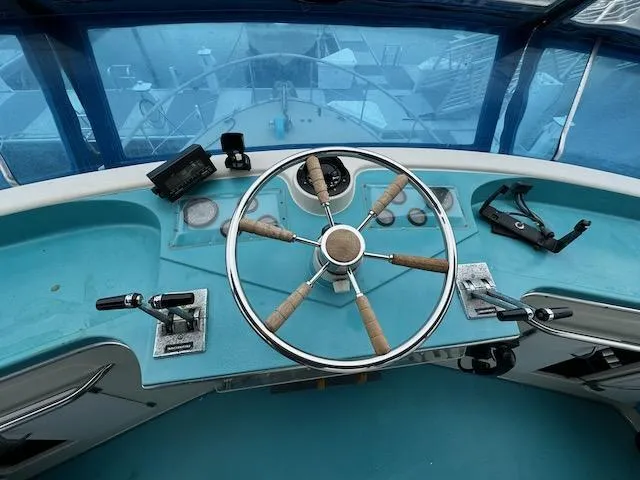 Slide: The Image of 1974 Tollycraft 40 Tri-Cabin helm with classic wooden steering wheel and controls. - 19