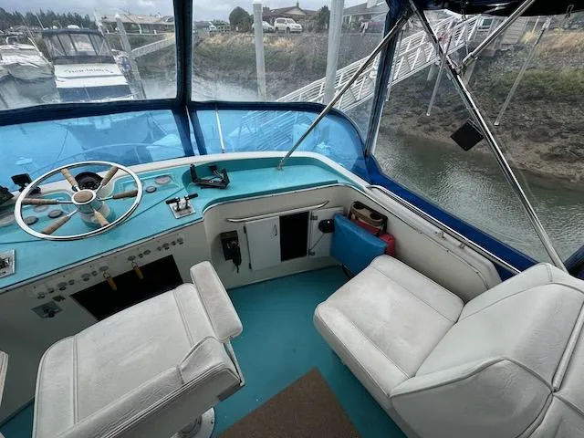 Slide: The Image of 1974 Tollycraft 40 Tri-Cabin helm with blue dashboard and white seating. - 20