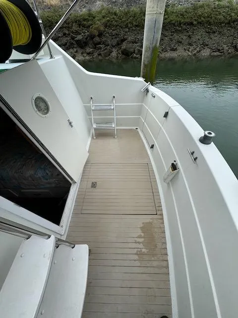 Slide: The Image of 1974 Tollycraft 40 Tri-Cabin boat deck with ladder and water view. - 3