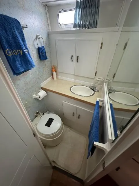 Slide: The Image of 1974 Tollycraft 40 Tri-Cabin bathroom with sink, toilet, and storage cabinets. - 31