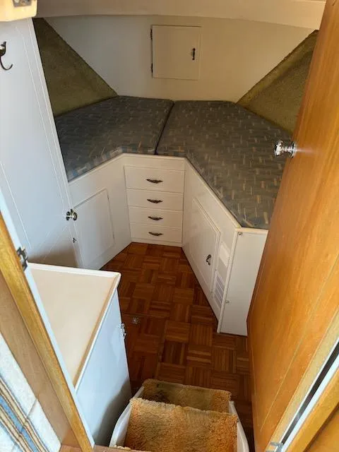 Slide: The Image of 1974 Tollycraft 40 Tri-Cabin interior with V-berth, wooden flooring, and storage cabinets. - 37