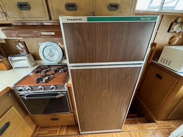 Slide: The Image of 1974 Tollycraft 40 Tri-Cabin kitchen with vintage stove and fridge. - 39