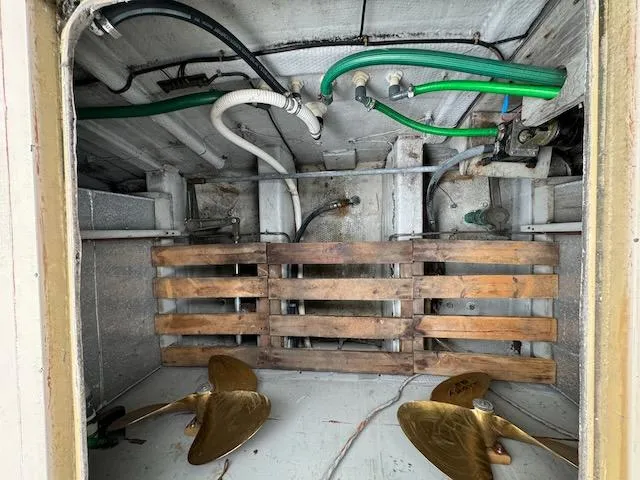 Slide: The Image of Engine room of 1974 Tollycraft 40 Tri-Cabin with propellers and piping. - 48