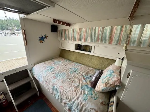 Slide: The Image of Cozy cabin interior of 1974 Tollycraft 40 Tri-Cabin with nautical-themed bedding. - 6