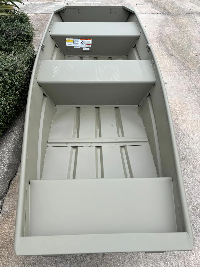 Slide: The Image of 2025 Tracker Grizzly 1236 Utility boat, interior view, gray color, on concrete surface. - 2