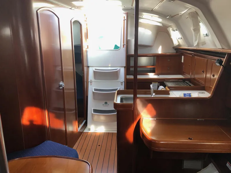 Slide: The Image of Interior of 2004 Beneteau 331 sailboat with wood finish and compact kitchen area. - 13
