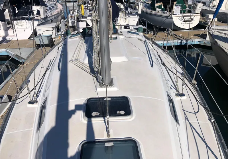 Slide: The Image of 2004 Beneteau 331 sailboat deck view at marina, showcasing rigging and hatches. - 19