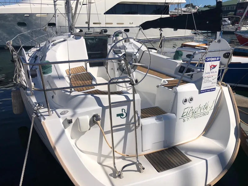 Slide: The Image of 2004 Beneteau 331 sailboat docked, featuring spacious cockpit and dual steering wheels. - 26