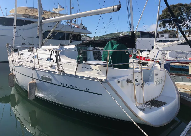 Slide: The Image of 2004 Beneteau 331 sailboat docked in marina, white hull, calm water reflection. - 27