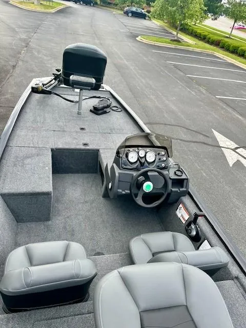 Slide: The Image of 2025 Tracker Pro 170 boat interior with steering console and seating in a parking lot. - 3