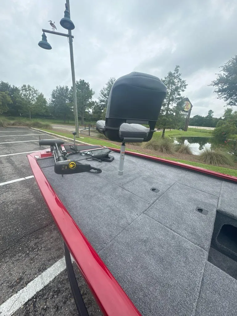 Slide: The Image of 2025 Tracker Pro 170 boat with fishing seat, parked near a pond. - 4