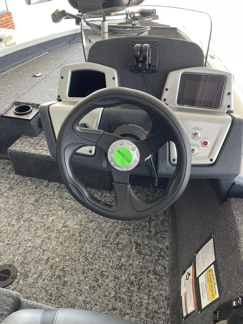 Slide: The Image of 2025 Tracker Pro Team 175 boat dashboard with steering wheel and control panels. - 12
