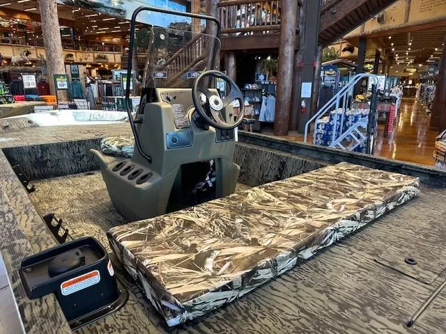 Slide: The Image of 2025 Tracker Grizzly 1860 CC boat interior with camouflage seating in a showroom. - 3