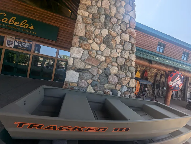 Slide: The Image of 2025 Tracker Grizzly 1036 Utility boat displayed outside Cabela's store. - 27