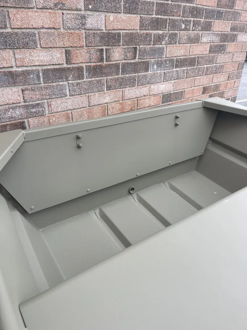 Slide: The Image of 2025 Tracker Grizzly 1036 Utility boat interior against brick wall. - 4