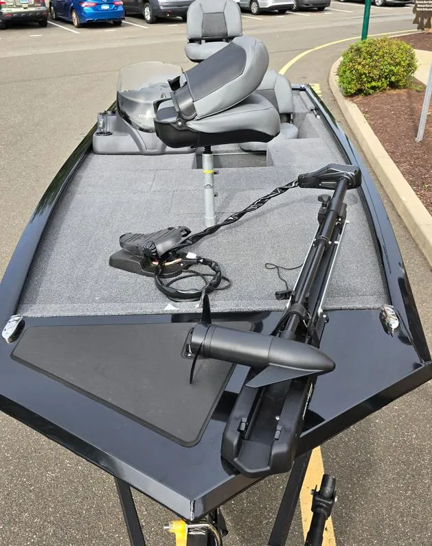 Slide: The Image of 2025 Tracker Pro 170 fishing boat with trolling motor and seating, parked in a lot. - 2