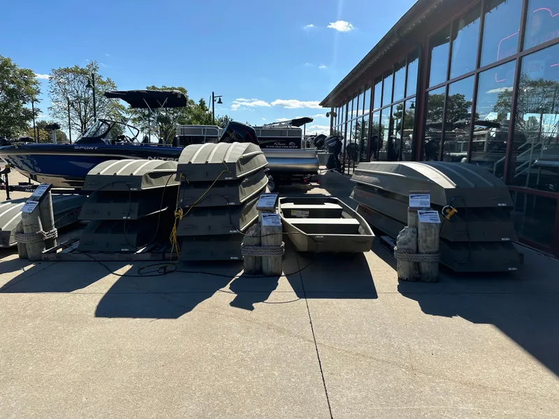 Slide: The Image of 2025 Tracker Grizzly 1036 Utility boats displayed outdoors in a showroom setting. - 2