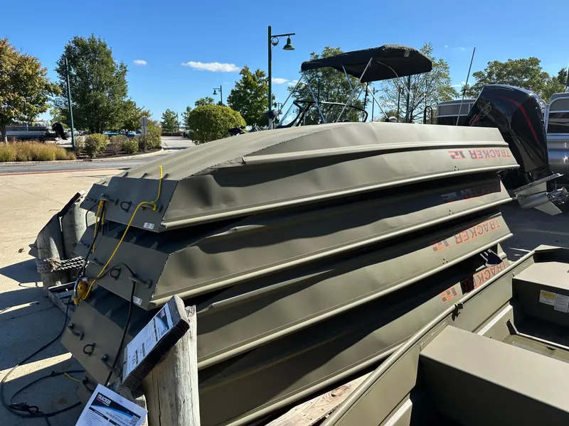 Slide: The Image of 2025 Tracker Grizzly 1036 Utility boats stacked outdoors under clear sky. - 27