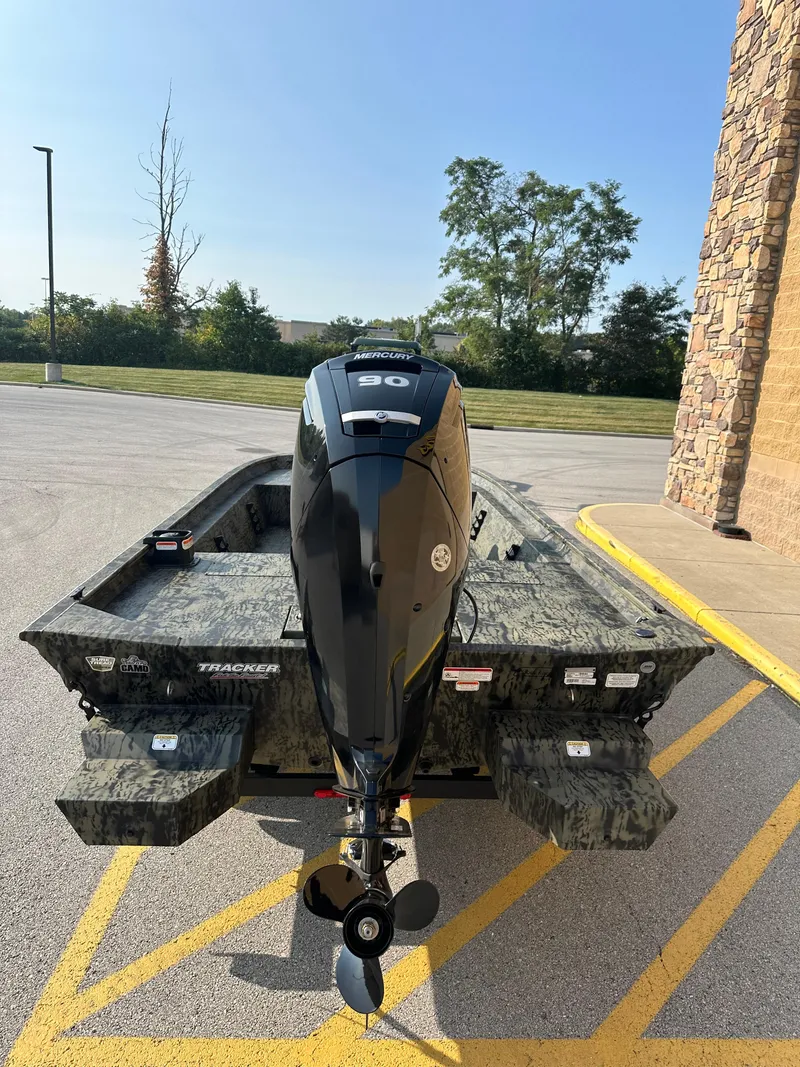 Slide: The Image of 2025 Tracker Grizzly 1860 CC boat with outboard motor in parking lot. - 3