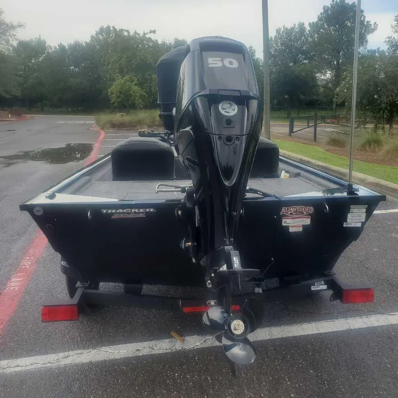 Slide: The Image of 2025 Tracker Pro 170 boat with 50 HP motor in parking lot. - 2