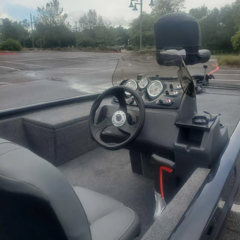 Slide: The Image of 2025 Tracker Pro 170 boat interior with steering wheel and dashboard in parking lot. - 4