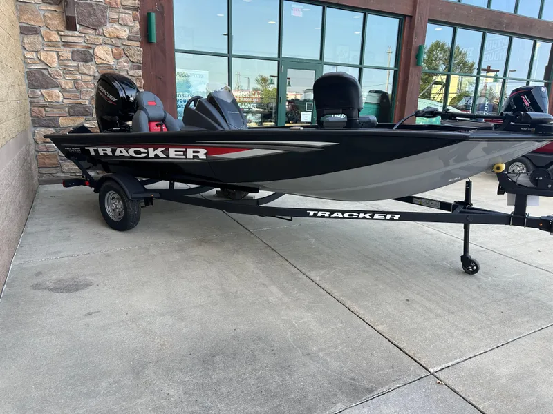 Slide: The Image of 2025 Tracker Pro Team 175 boat on trailer outside a building. - 2