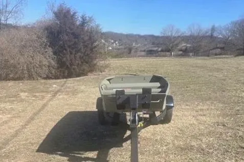 Slide: The Image of 2025 Tracker Grizzly 1036 Utility boat on grassy field. - 2