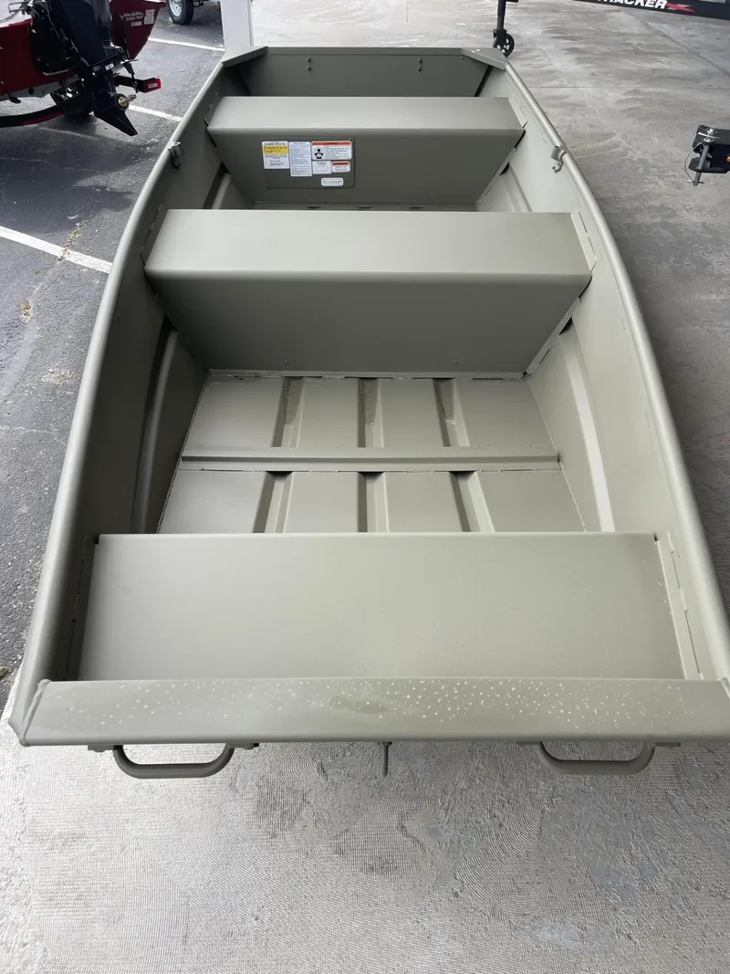 Slide: The Image of 2025 Tracker Grizzly 1236 Utility boat, interior view, parked on concrete surface. - 2