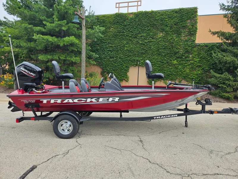 Slide: The Image of 2025 Tracker Pro Team 175 boat on trailer, red exterior, parked outdoors. - 2