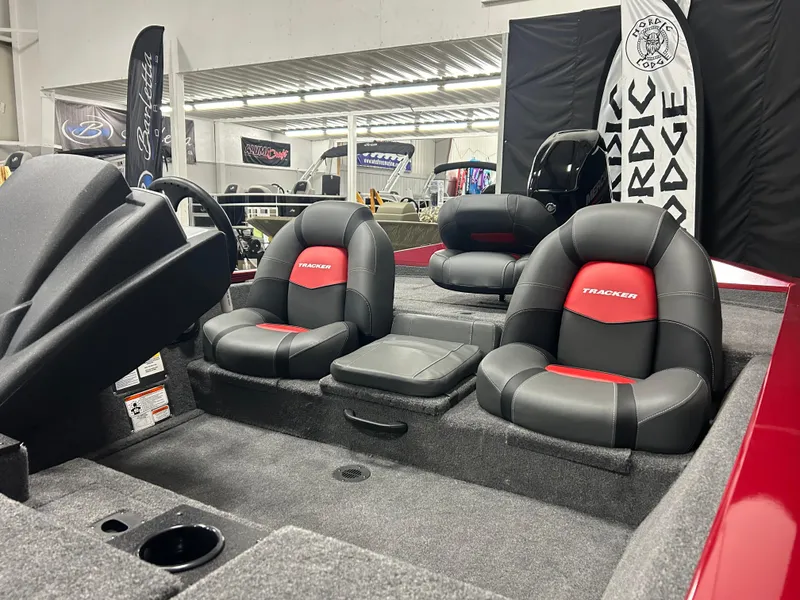 Slide: The Image of 2025 Tracker Pro Team 175 boat interior with black and red seating in showroom. - 8