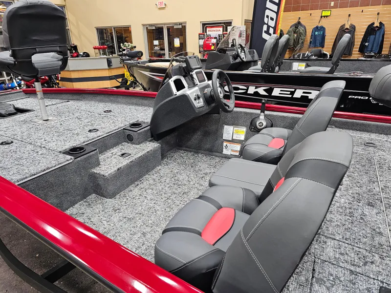 Slide: The Image of 2025 Tracker Pro Team 175 boat interior with gray and red seating, steering console, and carpeted deck. - 9