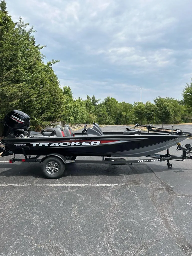 Slide: The Image of 2025 Tracker Pro Team 175 boat on trailer, parked outdoors. - 2