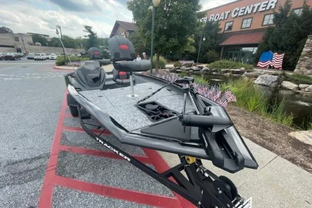Slide: The Image of 2025 Tracker Pro Team 175 boat parked outside a boat center. - 2