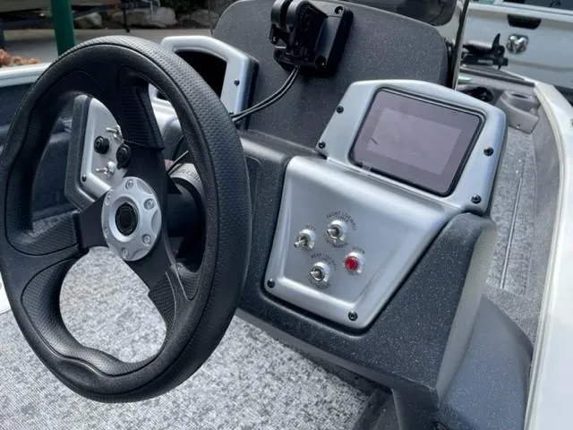 Slide: The Image of 2025 Tracker Pro Team 175 Crappie Edition boat dashboard with steering wheel and controls. - 2