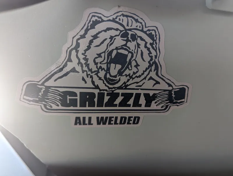 Slide: The Image of Sticker of roaring bear with "Grizzly All Welded" text on Tracker Grizzly 1036 Utility. - 2