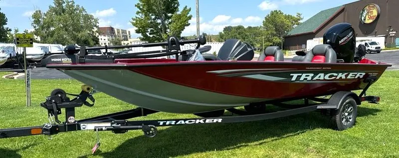 Slide: The Image of 2025 Tracker Pro Team 175 boat on trailer, parked on grass. - 2