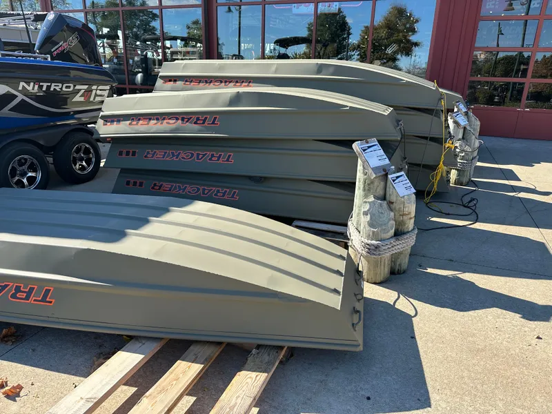 The Image of Stacked 2025 Tracker Grizzly 1036 Utility boats on display outside a showroom. - 0