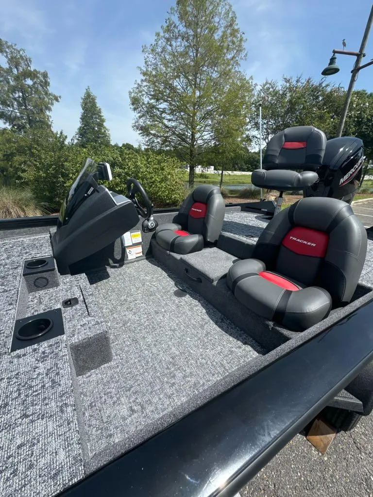Slide: The Image of 2025 Tracker Pro Team 175 boat interior with gray and red seating, steering console, and cup holders. - 5