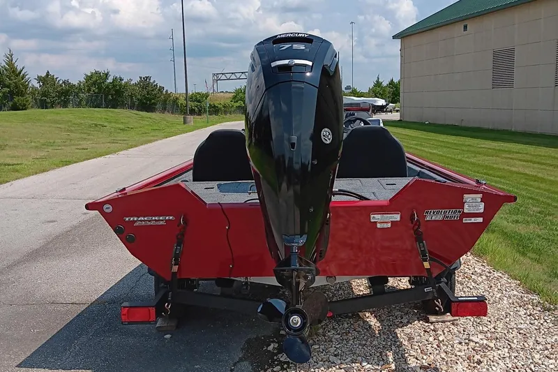 Slide: The Image of 2025 Tracker Pro Team 175 boat with outboard motor, parked outdoors. - 2