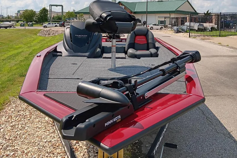 Slide: The Image of 2025 Tracker Pro Team 175 boat with Minn Kota trolling motor, parked outdoors. - 3