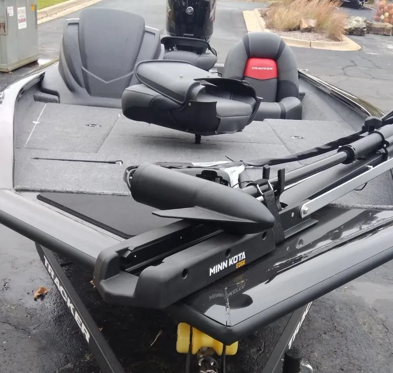 Slide: The Image of 2025 Tracker Pro Team 175 boat with Minn Kota trolling motor, gray and red seating. - 5